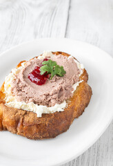 Gourmet sandwich layered with pate, cranberry jam, and cream cheese