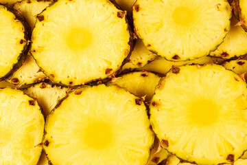 Pineapple juicy yellow slices background. Top view.