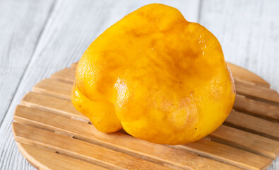 Whole Grilled Yellow Bell Pepper Served Bare On A Rustic Wooden Tray