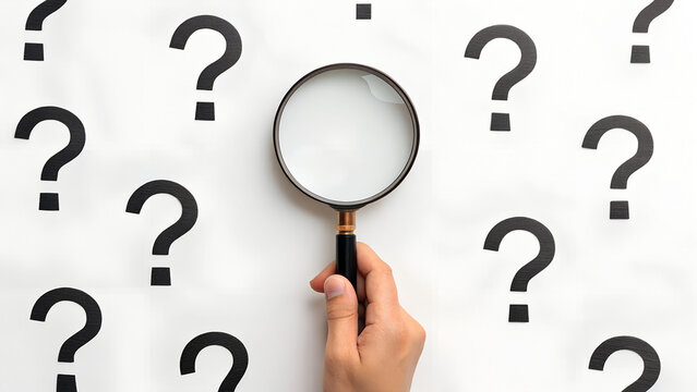 Hand holding magnifying glass over a pattern of question marks on white background. Search, investigation, or solution concept