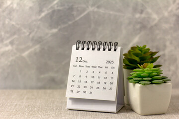 Hello, December 2025. Desktop calendar for planning on a gray background.