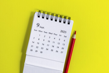 Hello, September 2025. Desktop calendar for planning on a yellow background.