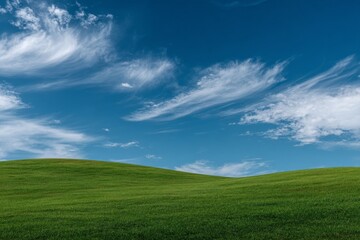 Fototapeta premium Bright green hills under a clear blue sky with wispy clouds on a sunny day