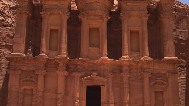 Rock-cut facade of the ancient Monastery (Ad Deir) carved into sandstone cliffs in Petra, Jordan.