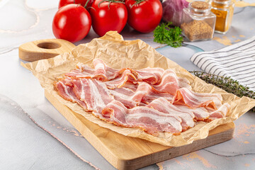 Sliced pork bacon over board