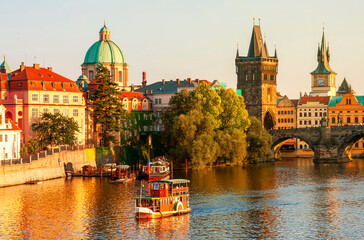 Charles Bridge and architecture of the Old Town in Prague, Czech republic. Pleasure ship on the Vltava river in Prague. Charles Bridge is the main attraction of Prague in Czech republic.