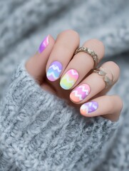 Naklejka premium Hand resting on a gray blanket with pastel painted nails