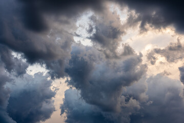 Clouds drift overhead in a sky filled with color and contrast, creating a dramatic scene rich in texture, shadow, and moody atmosphere, showcasing the subtle beauty and movement of nature.