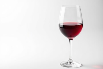 Single red wine glass, half-full, against pure white, drinkware, white background, liquid