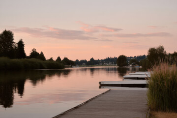Obraz premium serene summer evening at boat dock in washington with calm waters reflecting sunset