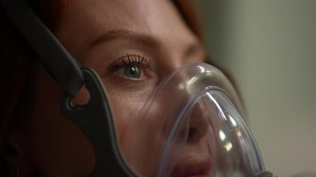 Close-up face of young woman patient performing respiratory training, comfortably breathing with oxygen mask connected to respiratory device, promoting lung capacity and overall respiratory health.