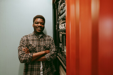 Professional technician stands confidently next to equipment in a tech environment, showcasing skills in a modern workspace