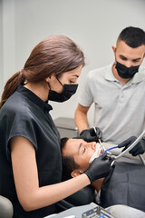 Dental experts in protective face mask providing high quality dental care