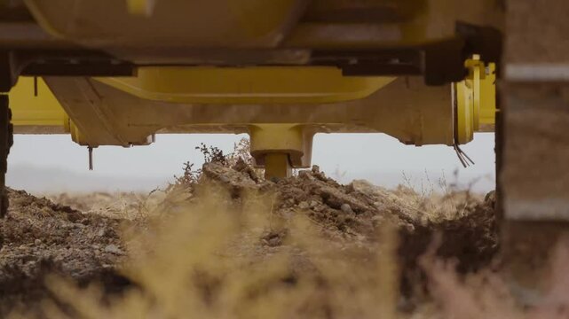 Close-up of a bulldozer loosens the soil
