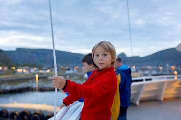 Family with kids and dog, traveling with ferry from Moskenesoya to Varoya with pet dog, dog in backpack