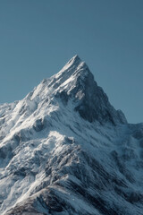 Majestic snowcapped mountain peak under a clear blue sky