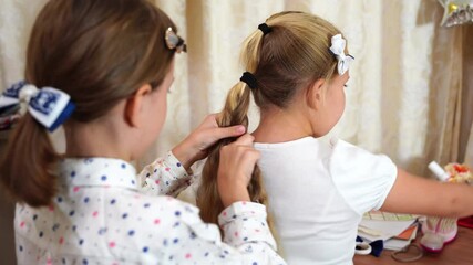 Two little girls friends getting ready for school in bedroom. Kid braids sisters hair. Children wear school uniforms. Morning routine. Doing homework, home lessons. Education back to school concept