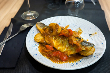 Grilled fish with bell peppers and sauce on plate