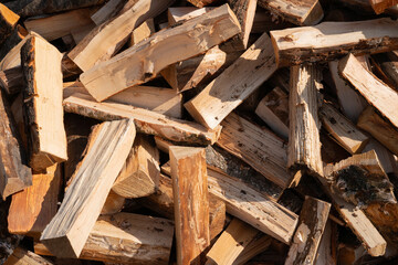 Stack of cut firewood logs in sunlight displaying natural texture