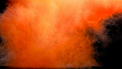 Large explosion with a massive cloud of smoke illuminated by a bright and fiery orange burst of light on a black background