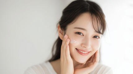 肌にスキンケアクリームを塗る日本人女性の笑顔クローズアップ、自然光で際立つ素肌と透明感（美容・コスメ・スキンケア・広告）