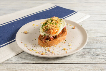 Delicious Egg-Topped Toast Garnished With Herbs and Crumbs Showcases Vibrant Flavors on a Rustic Wooden Table