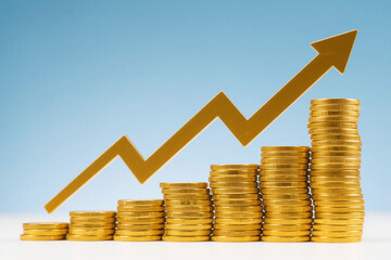 Photo of Stacks of golden coins with upward pointing arrow representing financial growth and success
