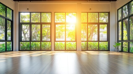Sunlit empty room with large windows and hardwood floor.