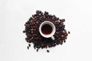 Top View of Coffee Cup Surrounded by Roasted Beans on White Background

