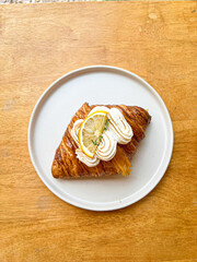 Lemon Cream Croissant on White Plate Over Wooden Table