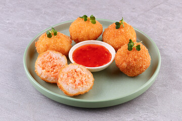 Crispy Salmon Rice Balls with Sweet Chili Sauce on Green Plate