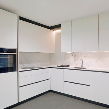 cocina en esquina de estilo moderno con mobiliario en blanco