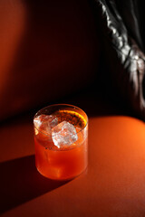 Classic orange cocktail with ice cubes served in a rocks glass nightclub restaurant, close-up