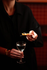 Elegant Hand Holding a Modern Cocktail with Caviar Garnish..