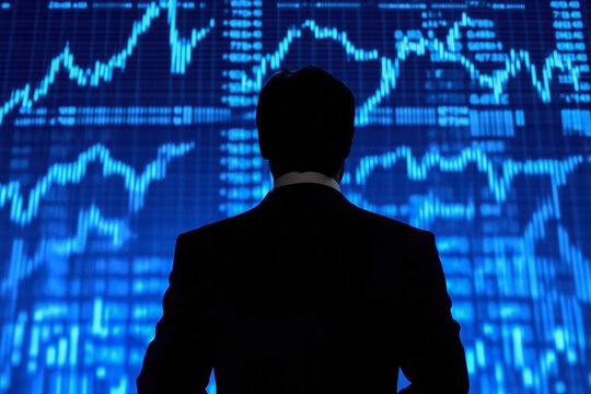 Financial news anchor discussing market trends, with stock tickers and economic charts displayed on the screen behind them