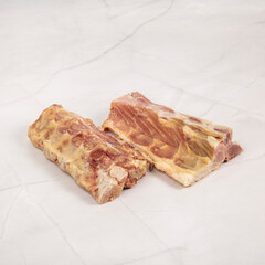 Close up view of two sections of raw pork ribs on marble surface – High Resolution Raw Meat Image for Food Industry or Food Packaging