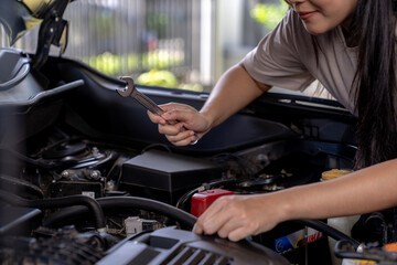 A young woman checking her car engine before a long road trip