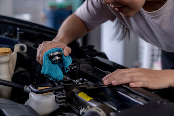 A young woman checking her car engine before a long road trip