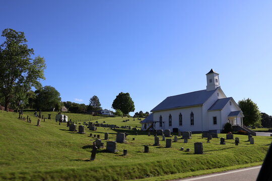 old white church on the hill with a graveyard