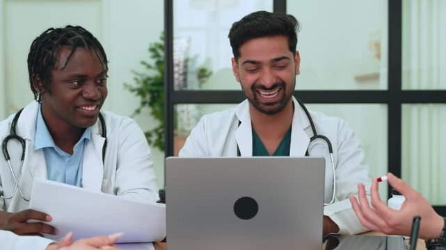 Healthcare workers analyzing patient data, discussing medical records in bright conference room, representing multidisciplinary professional collaboration and teamwork. Diverse medical staff working 