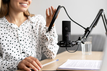 Radio host speaking into microphone while recording podcast