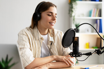 Content creator recording podcast using professional microphone and headphones