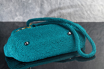 Green women's handbag, hand-knitted, with a brooch and a long handle. Details