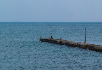 Man Fishing Alone on Haraoka Pier over a Calm Sea, Chiba, Japan