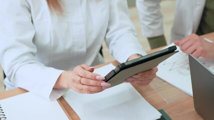 Medical Business professionals doctors collaborating, reviewing financial data using digital tablet and paper charts, representing teamwork and strategic analysis in contemporary corporate environment - Powered by Adobe