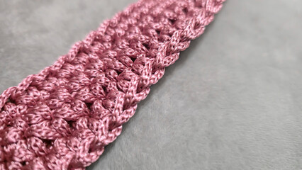 Knitting elements of a pink women's bag, hand knitting with a long handle.