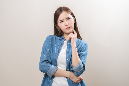 Portrait of face expression stress, asian young woman, confused girl standing pose looking camera in casual. unhappy female thinking creative, thinks about problem, isolated on background, copy space.