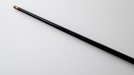 An isolated black cue stick with a gold tip displayed on a bright, plain white backdrop.