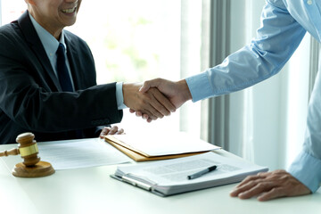 Business people in an law firm office establishing a corporate agreement with a handshake