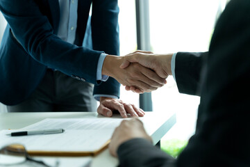 Business people in an law firm office establishing a corporate agreement with a handshake